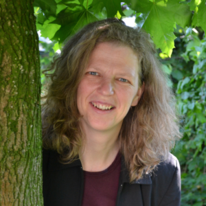 Porträt der Interviewpartnerin Susanne Schubert (an einen Baum gelehnt)